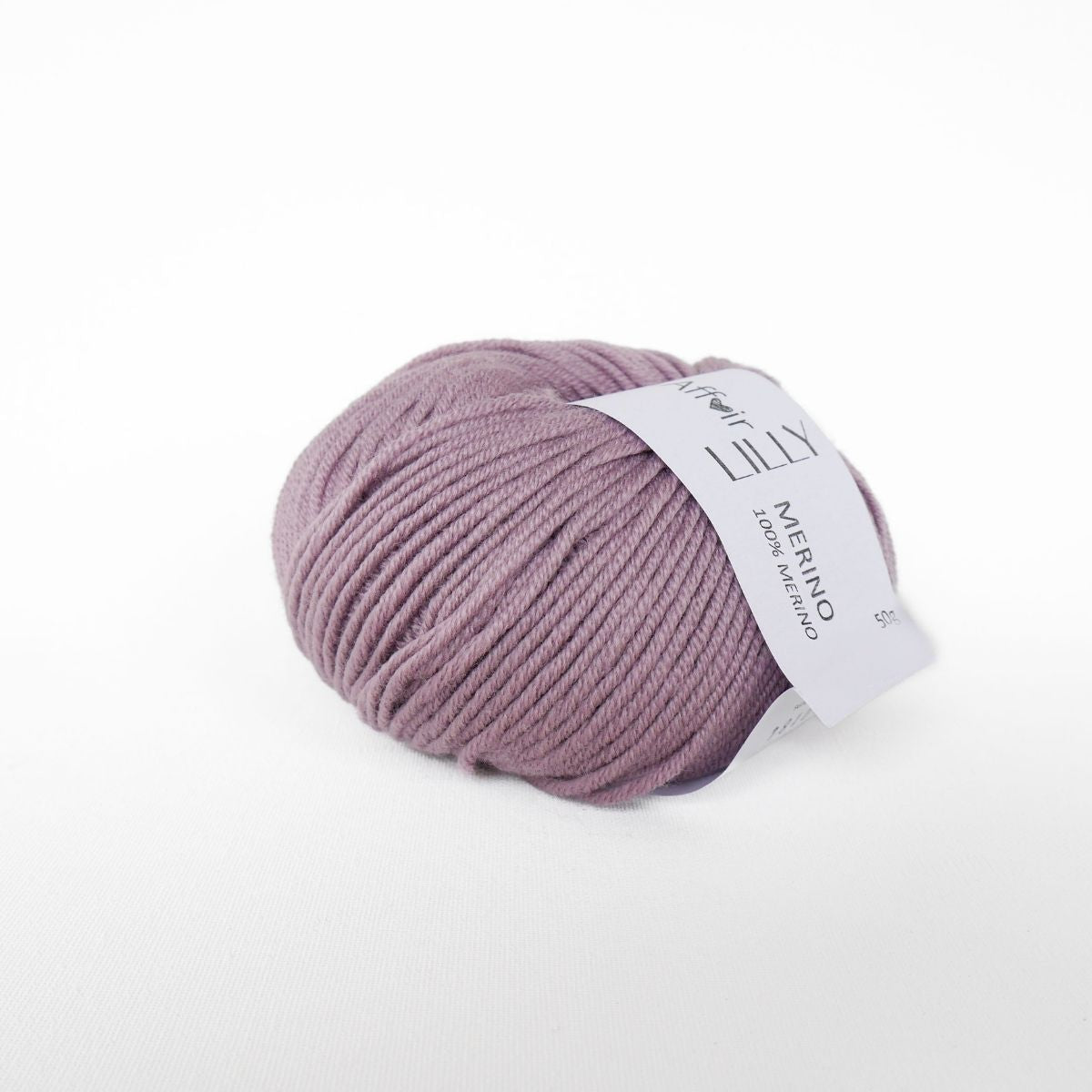 Wollknäuel in mauve mit Wickelbandetikett