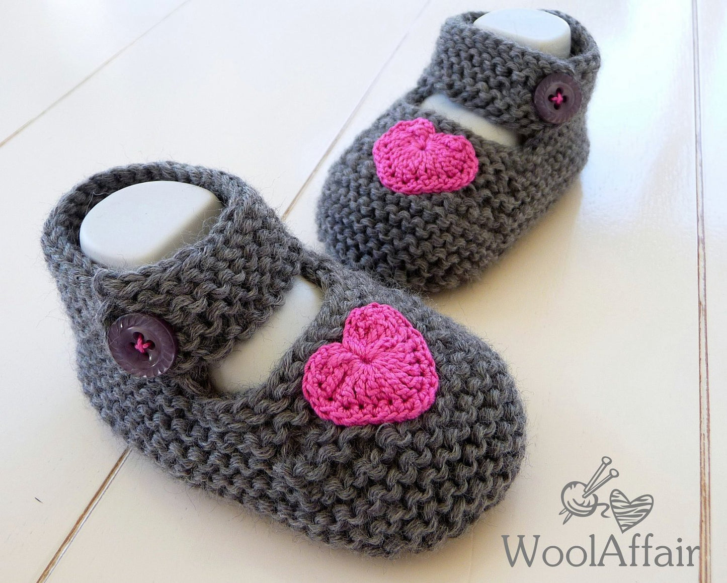 Strickanleitung für Babyballerinas: graue Wollschuhe mit pinken Herzapplikationen